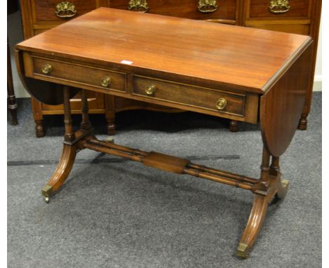 A Reprodux mahogany sofa table, two drawers to frieze, turned double refectory stretcher, drop leaf, fluted outswept legs cap