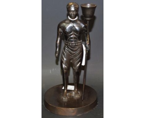 A dark patinated figural candlestick, as a tribesman