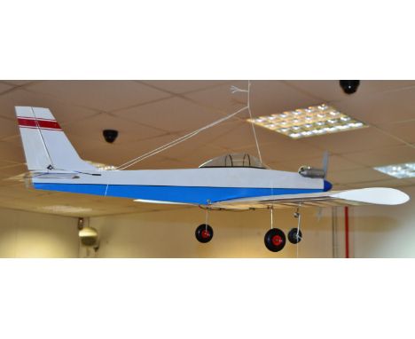 A Radio controlled hand made single wing Airplane, wooden painted blue and white fuselage, Petrol Os Max 22 engine, Skyleader