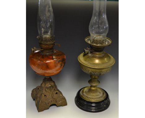 A late Victorian oil lamp, tangerine glass reservoir, cast iron base; another dressed brass body (2)