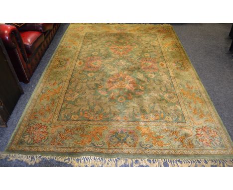 An Egyptian carpet Royal Agra decorated with leafing foliage in hues of ochre, russet and caramel on a green ground. 280cm x 