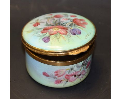A Kingsley enamel circular box and hinged cover, painted overall with garden flowers, signed N Reed