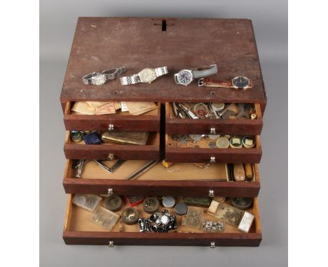 A small bank of six drawers containing a collection of watch makers spares and repairs along with small collection of wristwa