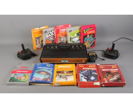 An Atari CX2600 gaming console, with two controllers. Together with ten gaming cartridges including Pac-Man, Frogger, Combat,