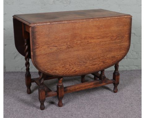 An oak drop leaf gate leg table, with barley twist supports. Height: 74cm, Width (extended): 136cm, Depth: 91cm