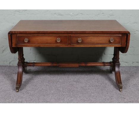 A Regency style mahogany sofa table, with two lower drawers and twin stretcher. Raised on casters. Height: 56cm, Width (leave