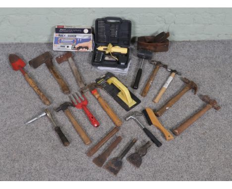 A box of assorted tools, including hammers, axes, a hand plane and an electric drill set, among other items.