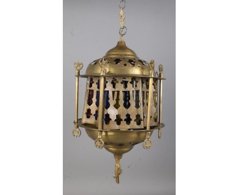 A Moroccan style brass hanging lantern featuring concave pierced panels surrounding coloured glass and star finial. Approx. h