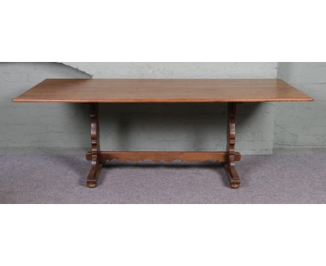 A large Ercol style dining table, with central stretcher. Height: 71cm, Width: 213cm, Depth: 92cm.
