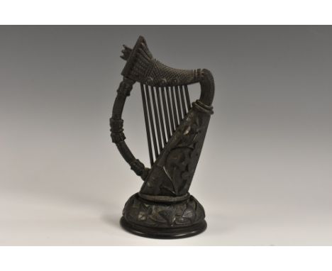 A 19th century Irish bog oak model, of a harp, carved with shamrocks, domed circular base, 17cm high, c.1880