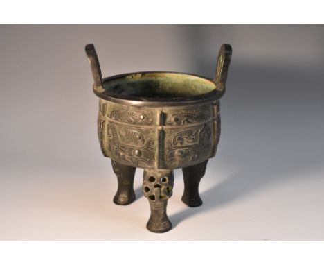 A Chinese dark patinated ding tripod censer, in the Archaic taste, lug handles, characters to base, 18cm high