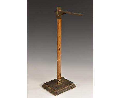 An early 20th century shop counter vertical measure, 17" boxwood scale, rectangular oak base, 47.5cm high