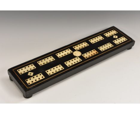 A 19th century Colonial ebonised and ivory cribbage board, inlaid with rectangular reserves centred by a roundel, outlined wi