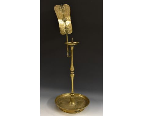 A Chinese brass pricket candle lamp, the banner shaped shade applied with bats and engraved with a fretted roundel, scrolling