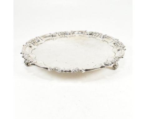 An early 20th century hallmarked silver salver. The Edward VII salver having three scroll feet and a stepped serpentine scrol