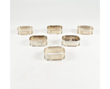 A set of six hallmarked silver napkin rings. The napkin rings having an engine turned pattern with central monogrammed cartou