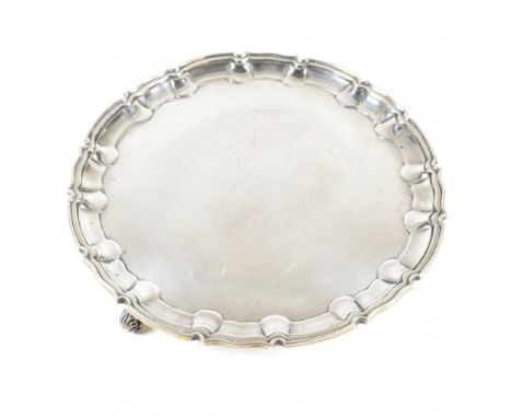 A Victorian hallmarked silver presentation salver. The salver having three scroll feet rising to circular form with serpentin