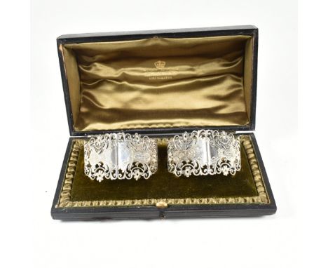 A cased pair of Edward VII hallmarked silver napkin rings. The early 20th century napkin rings of triangular form having a pi