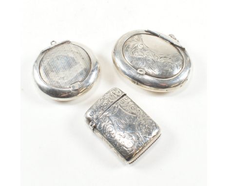 A Victorian hallmarked silver vesta case and two later compacts. The vesta case having an etched scroll design with central m