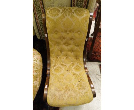 A Victorian walnut framed button upholstered nursing chair with scroll design raised on scroll feet 