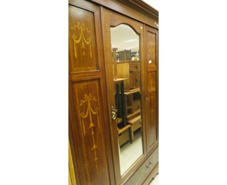 An Edwardian mahogany and inlaid single door wardrobe with swag decoration, the whole above a single drawer to bracket feet