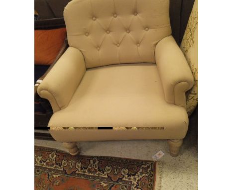 A beige button back wide seat single armchair