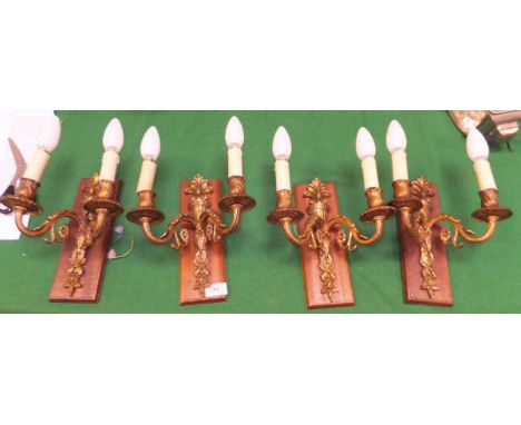 A set of four gilt twin branch wall light fittings