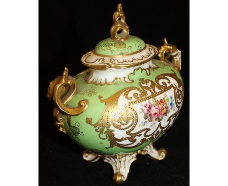 A Royal Crown Derby porcelain vase and cover decorated with gilt relief work and central floral spray on a pale green ground,