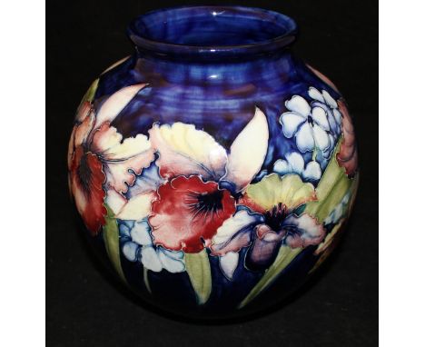 A Moorcroft vase decorated with iris and other flowers on a deep blue ground, bears signature and stamps to base CONDITION RE