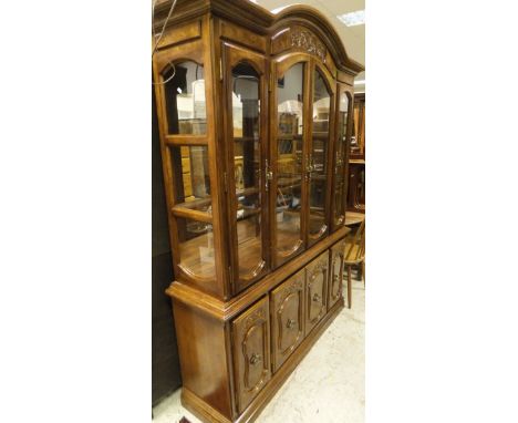 A 20th Century display cabinet with four glazed doors enclosing two glazed shelves on a base of four cupboard doors together 