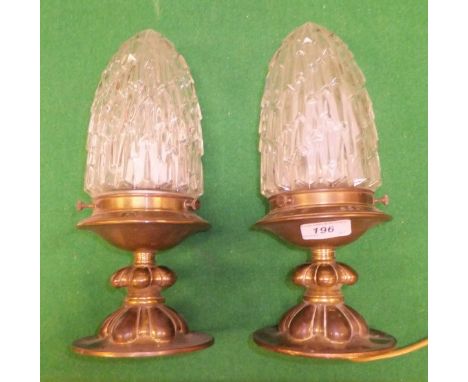 A pair of brass ceiling light fittings with stepped cut glass shades