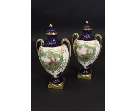A pair of Royal Worcester two handled vases decorated with panels of cattle by water's edge by James Stinton, raised on circu