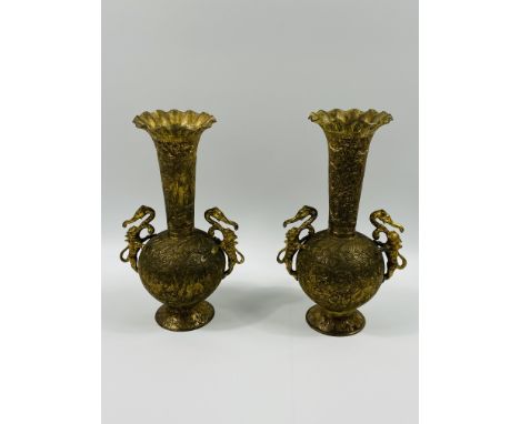 A pair of gilt metal vases with decorative handles, 29cms high. Estimate: £15-30.This item qualifies for in-house posting.