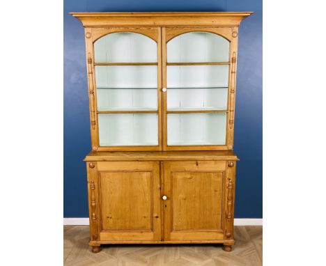 A Victorian pine dresser with a pair of arched top glazed doors, plate shelves to the interior, above a pair of panelled door