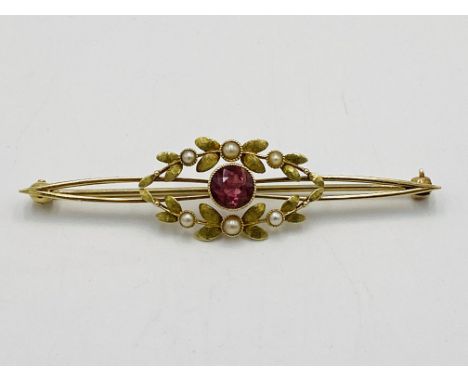 Belle epoque 15ct bar brooch set with a single mille grain pink sapphire in laurel leaf surround punctuated with seed pearls,
