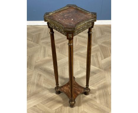 An early 20th century French lamp table with a rouge marble top and shaped brass gallery, shaped undertier below, raised upon