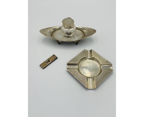 A silver ashtray with engine turned finish, 70g; together with an Asprey ink well on stand. Estimate: £60-80.This item qualif