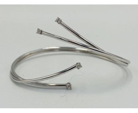 18ct white gold bangle set with four diamonds, 9.5g. Estimate: £340-380.This item qualifies for in-house posting.