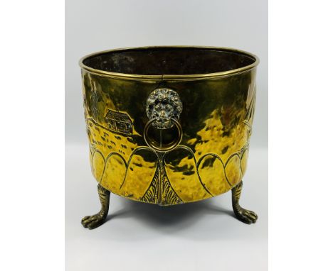 A 19th century circular Dutch brass log bin with a hammered finish depicting sailors passing by a windmill,lion mask handles 