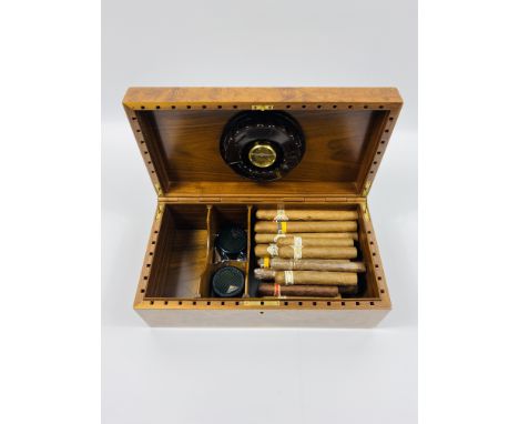 A burr elm cased humidor and contents (approx 25 various cigars).36cms wide x 19.5cms deep x 12.5cms high.Estimate £30-50.Thi