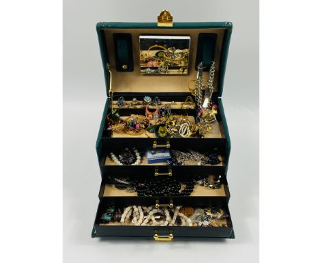 A quantity of costume jewellery in a faux leather jewellery box. Estimate: £20-40.This item qualifies for in-house posting.