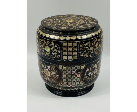 An early 20th century chinese style mother of pearl inlaid cylindrical box with a red lacquered interior.23cms high x 21cms d