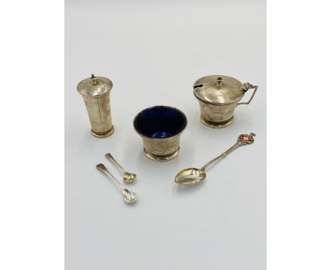 A silver three piece cruet, 117g, Birmingham 1922; together with three silver spoons, 15g. Estimate: £60-80.This item qualifi