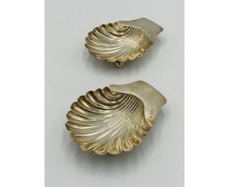 A pair of silver shell dishes, approximately 10cm wide, each on three ball feet, 138g, London 1908. Estimate: £70-100.This it