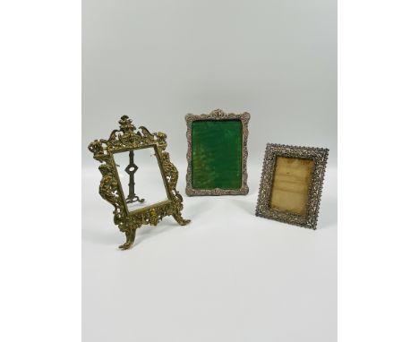 A decorative silver photo frame (19cms wide x 26cms high),together with a gilt white metal photo frame (14cms wide x 18.5cms 