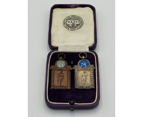 A silver NAAFI tag together with a bronze NAAFI tag, both with enamel cartouches, in original box. Estimate: £30-50.This item