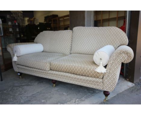 Steed Upholstery Two Seater Sofa, cream and green upholstered fabric, raised on wooden legs and brass castors