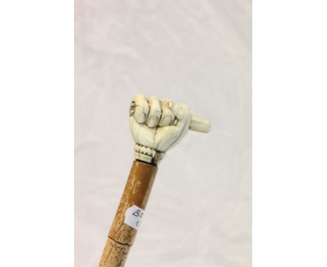 A vintage walking stick with carved ivory clenched fist possibly Masonic.