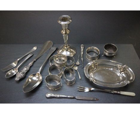 A collection of silver items including 7 napkin rings, single weighted candlestick, pierced dish and various other items 
