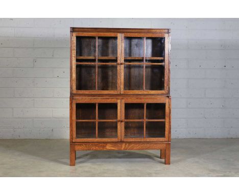 A Heal's oak glazed bookcase, c.1930, with two pairs of bar-glazed doors, raised on short square supports,88cm wide28cm deep1